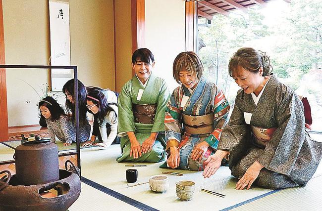 一服を楽しんだ後、茶わんを拝見する来場者＝松江市殿町、松江歴史館