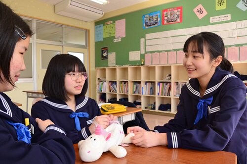 卒業を間近に控え友人と語り合う岡山祐子さん（右）＝浜田市旭町今市、旭中学校