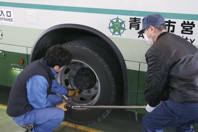 青森県八戸市の脱輪事故を受け、バスのタイヤのナットを締め直す「増し締め」を行う整備士＝１１日午前、青森市