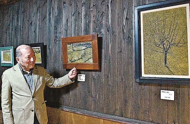 自作を紹介する寺井寿一さん＝益田市あけぼの東町、ギャラリー喫茶うつわ