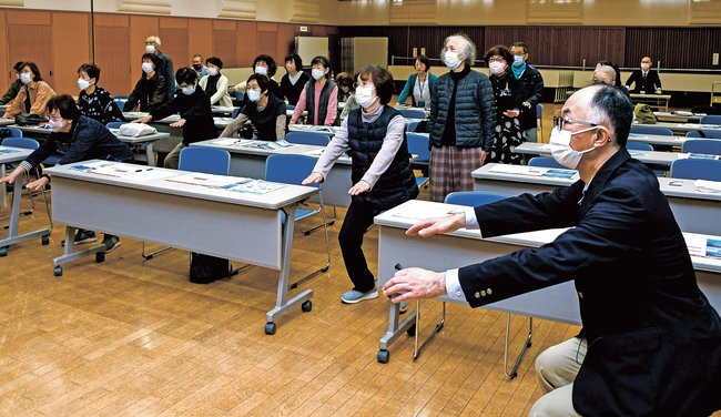飛田正敏整形外科部長（右）の指導で、スクワットのトレーニングをする参加者＝出雲市今市町、パルメイト出雲