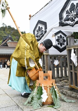 御饌井からくみ上げた若水をおけに移す神職＝出雲市大社町杵築東、出雲大社