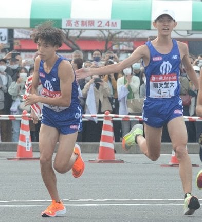 たすきを受け取り、走り出す順大の三浦龍司（左）＝第１中継所
