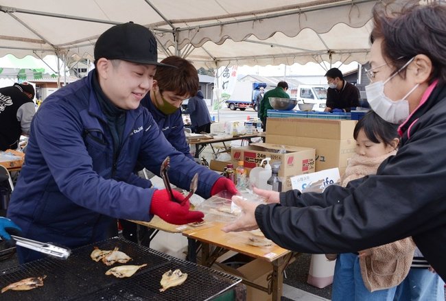 ノドグロの炭焼きを来場者（右）に振る舞う出店者＝浜田市原井町