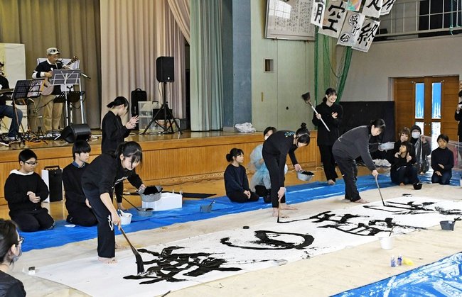 生演奏をバックに書道のパフォーマンスを披露する五風会の会員ら＝益田市大草町、北仙道公民館