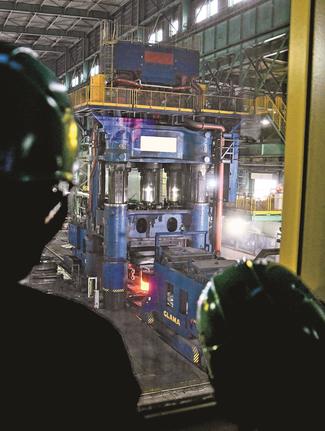 １万㌧級の大型鍛造プレス機を見学する参加者＝安来市飯島町、プロテリアル安来工場（画像の一部を加工しています）