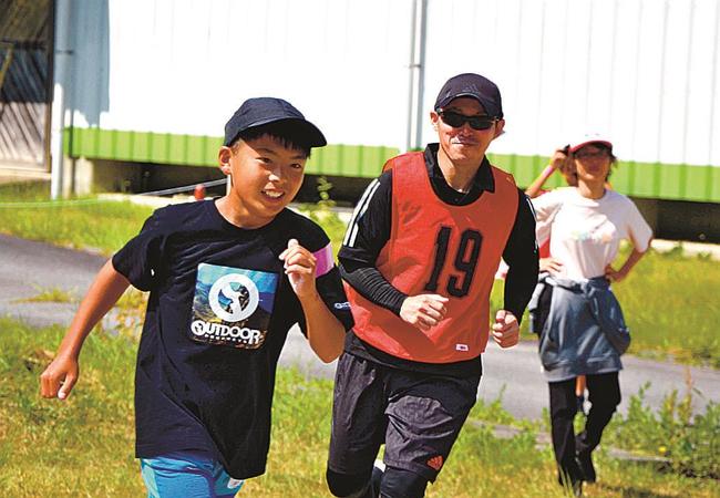 ゼッケンを着けたハンター役から逃げる児童（左）＝浜田市金城町久佐、かなぎウエスタンライディングパーク