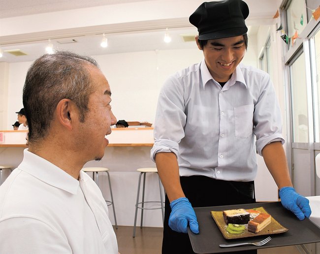 「おきらくカフェ」で接客する生徒（右）＝島根県隠岐の島町城北町、隠岐養護学校