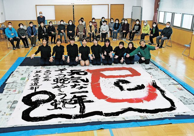 ２０２５年の干支「巳」を題材にした作品を仕上げた益田高校書道部（前列）＝益田市高津２丁目、高津公民館