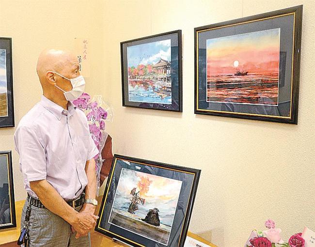 夕焼けを描いたすやまさんの作品を鑑賞する来場者＝米子市両三柳、コミュニティプラザ百花堂