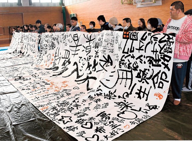 夢や好きな言葉を書き上げた和紙を広げ、記念撮影する参加者=米子市皆生3丁目、米子サン・アビリティーズ