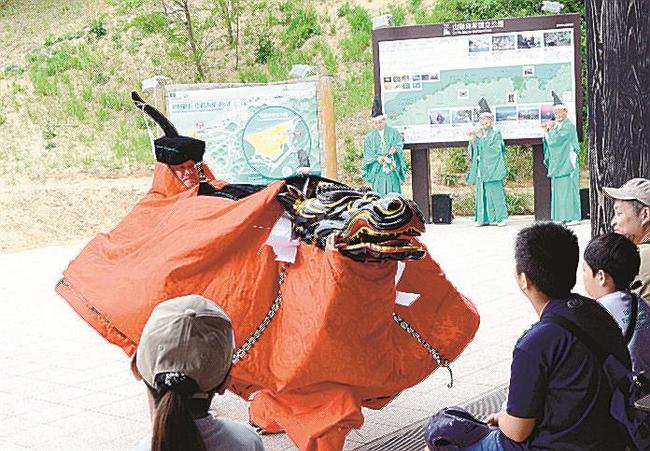 鳥取砂丘をバックに舞う米岡神社麒麟獅子舞保存会のメンバー＝鳥取市福部町湯山、鳥取砂丘ビジターセンター