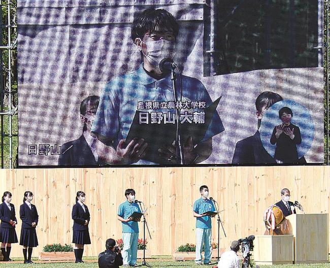 大会宣言で循環型林業確立への決意を新たにする日野山大輔さん（左から５人目）＝大田市三瓶町、三瓶山北の原