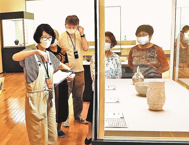 山本麻代主任学芸員（中央）の解説を聞く参加者＝益田市有明町、島根県立石見美術館