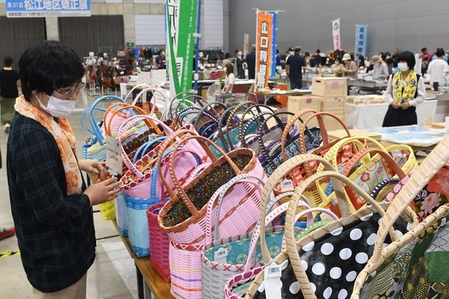 受刑者が作った製品を品定めする来場者=松江市学園南1丁目、くにびきメッセ