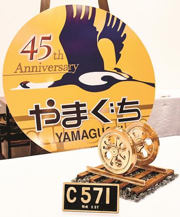 「Ｃ５７」の動輪の再現製品（手前）とＳＬやまぐち号の運行４５周年を記念するオリジナルヘッドマーク