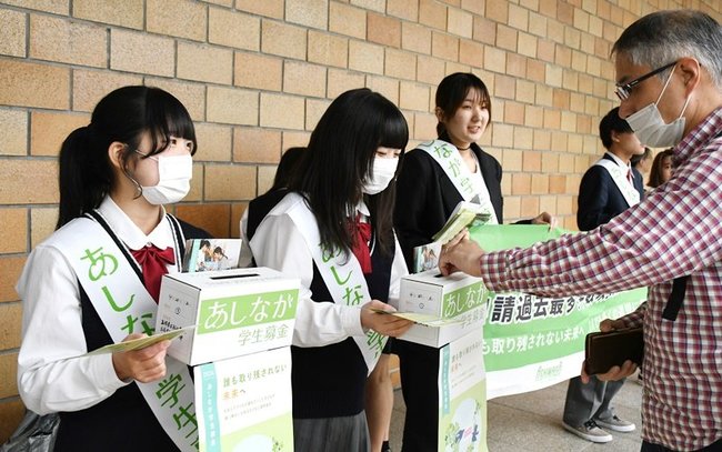 通行者（右）から募金を受け取る高校生＝松江市朝日町、ＪＲ松江駅北口