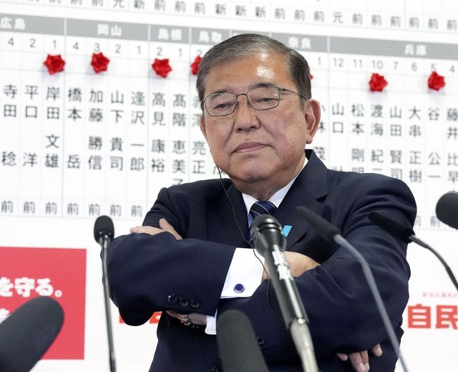 衆院選開票を受け、メディアのインタビューの合間に腕組みする自民党総裁の石破茂首相＝１０月２７日午後１１時１分、東京・永田町の党本部