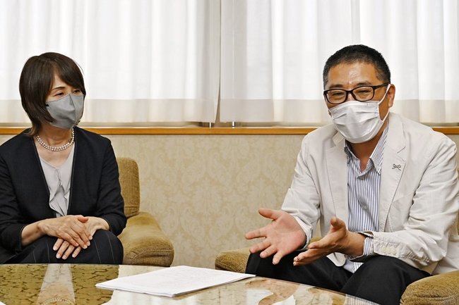 内閣府特命担当大臣表彰を報告する関口晃司さんと妻の英子さん＝益田市常盤町、市役所