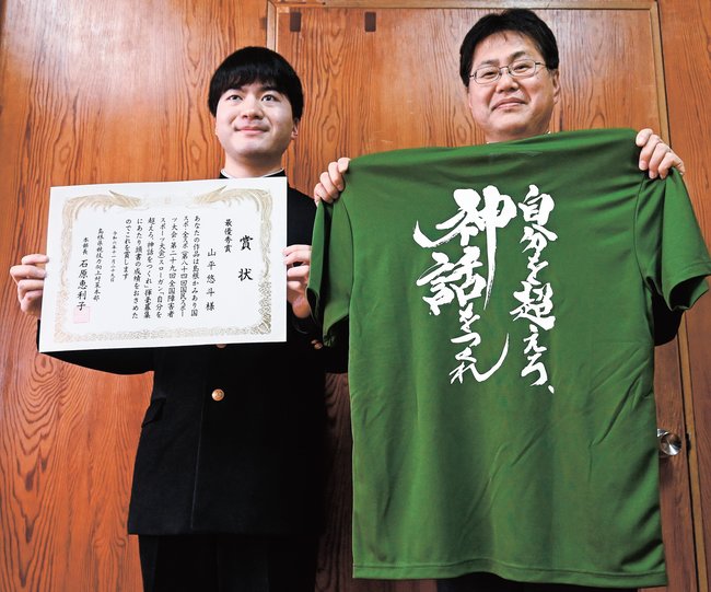 最優秀に選ばれた山平悠斗さん（左）と揮毫作品を印字したＴシャツ＝浜田市黒川町、浜田高校