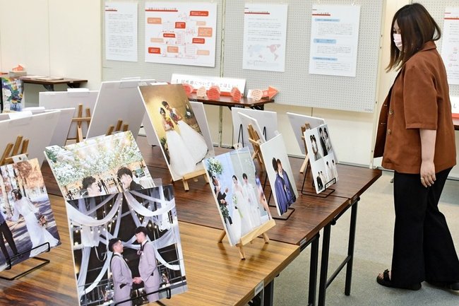 多様なカップルの写真を見る来場者＝松江市殿町、島根県民会館