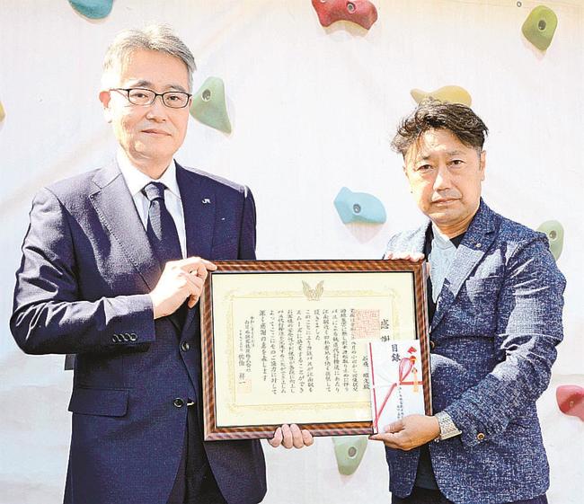 感謝状を受け取った石飛昭文さん（右）＝出雲市塩冶町、出雲すみれ保育園