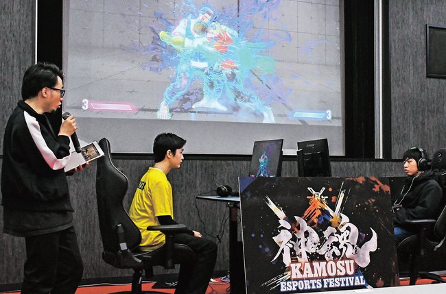 ｅスポーツイベントで対戦する参加者と解説するプロ選手（左）＝松江市大庭町、立正大淞南高校