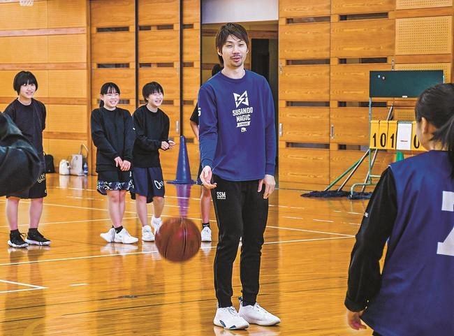 北川弘選手（中央）から指導を受ける東出雲中学校女子バスケットボール部の生徒たち＝松江市東出雲町揖屋、東出雲中学校
