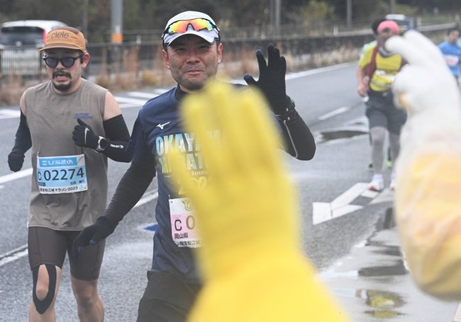 「あと２キロ。頑張って」。沿道スタッフの声に選手の顔が思わず笑顔が浮かぶ ＝松江市西川津町