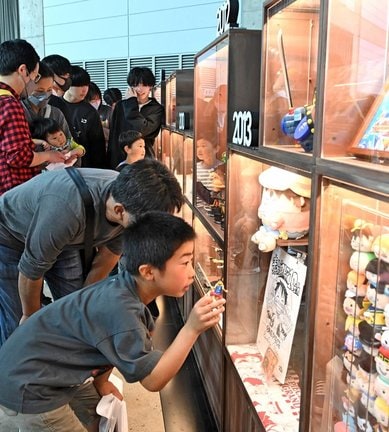 連載開始以降２５年分のキャラクターグッズの展示に見入る来場者＝松江市学園南１丁目、くにびきメッセ