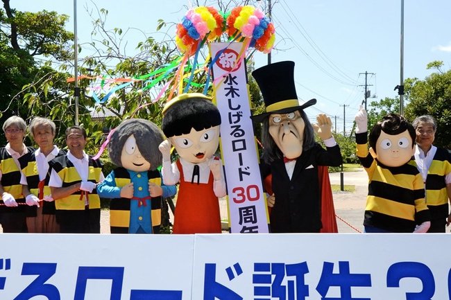 着ぐるみの鬼太郎などと共にくす玉を割り、水木しげるロード誕生30周年を祝う関係者=境港市大正町、駅前公園