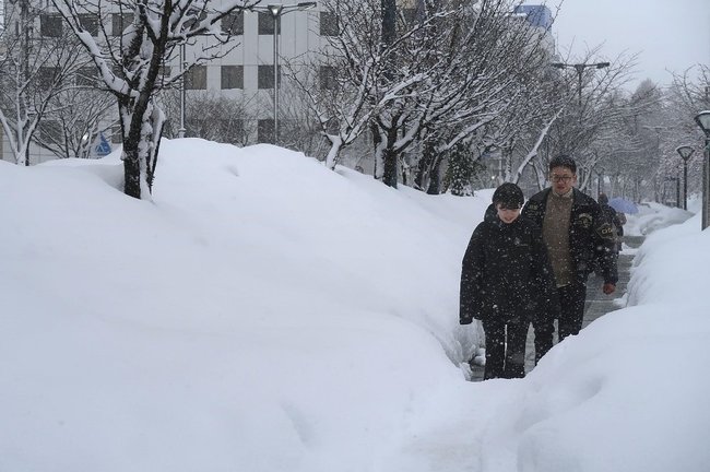 雪が積もった青森市中心部を歩く人＝１月８日