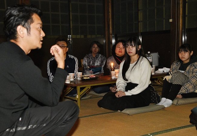 西尾光平さん（左端）の怪談話に聞き入る参加者＝江津市江津町、東向寺