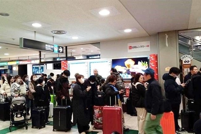 羽田行きの第1便が欠航となり、払い戻しなどのため列に並ぶ帰省客ら=出雲市斐川町沖洲、出雲空港