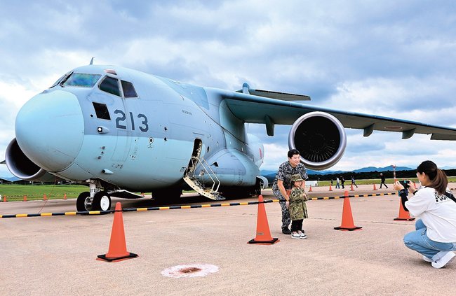 C2輸送機と記念撮影する親子=益田市内田町、萩・石見空港