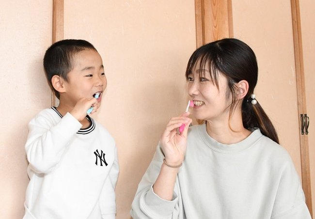 晴斗ちゃん（左）と一緒に歯磨する古新亜珠美さん＝島根県飯南町下赤名