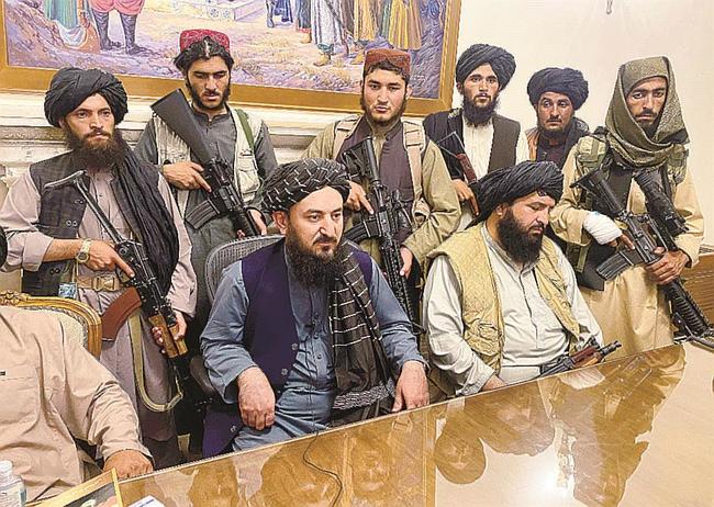 １５日、カブールのアフガニスタン大統領府を占拠した反政府武装勢力タリバンの戦闘員ら（ＡＰ＝共同）