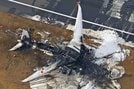 焼け焦げた日航機＝３日午前８時１０分、羽田空港（共同通信社ヘリから）