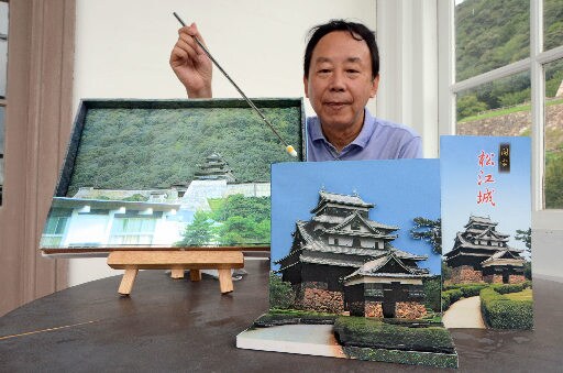 初公開となる松江城のペーパークラフトを紹介する神谷佳友さん。左は鳥取城＝鳥取市東町２丁目、仁風閣