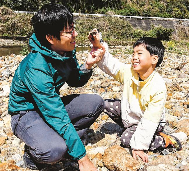 河原で鉄滓を見つけ、喜ぶ参加者＝出雲市多伎町口田儀