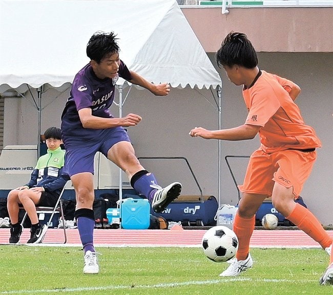 【サッカー男子１回戦・益田－三刀屋】前半２０分、益田のＦＷ森脇碧（左）が先制のシュートを決める＝益田運動公園陸上競技場
