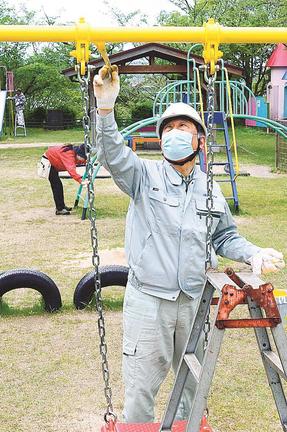遊具のペンキを丁寧に塗り直す会員＝大田市大田町、代官山動物園