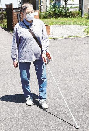 白杖を使って歩く日吉和子さん。歩行訓練士の指導を待っている状況で「正しい使い方ができているのか」と不安を漏らす＝松江市内