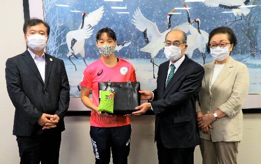 入江聖奈選手（左から２人目）に記念品を贈る東京鳥取県人会の関係者＝東京都世田谷区、日体大