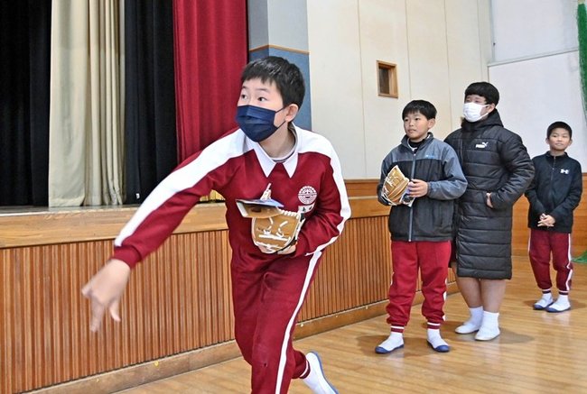 大谷翔平選手から贈られたグラブをはめてキャッチボールする吉田小の児童＝益田市中吉田町