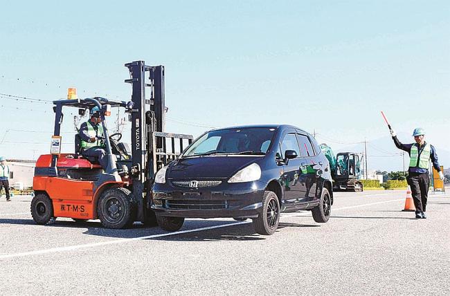 訓練で、放置車両をフォークリフトで移動する作業員ら＝米子市旗ケ崎、米子港