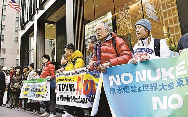 日本政府に核兵器禁止条約への参加を求め、日本総領事館前で横断幕を掲げる集会の参加者＝１１月３０日、米ニューヨーク（共同）