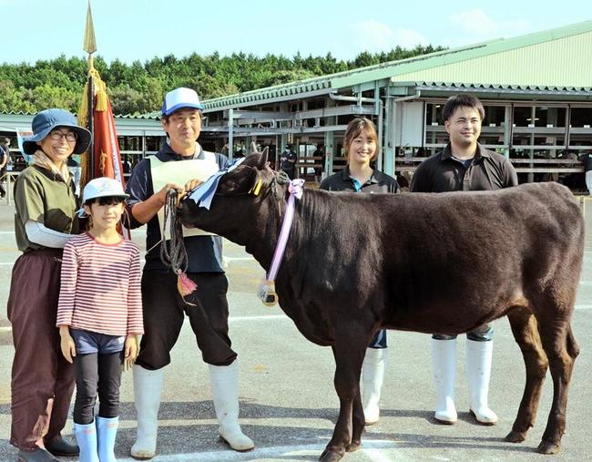 出品牛がグランドチャンピオンを獲得した宮崎美知子さん（左）＝鳥取県琴浦町湯坂、県中央家畜市場