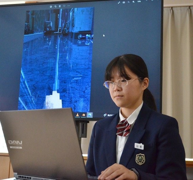 パソコンと向き合う山根麻由美さんと、県展で知事賞を受賞した作品「Luna(ルナ)」=出雲市西林木町、出雲北陵高校