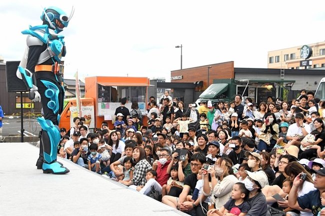 仮面ライダーショーを観賞する親子連れ＝出雲市今市町北本町４丁目、出雲プロジェクト用地